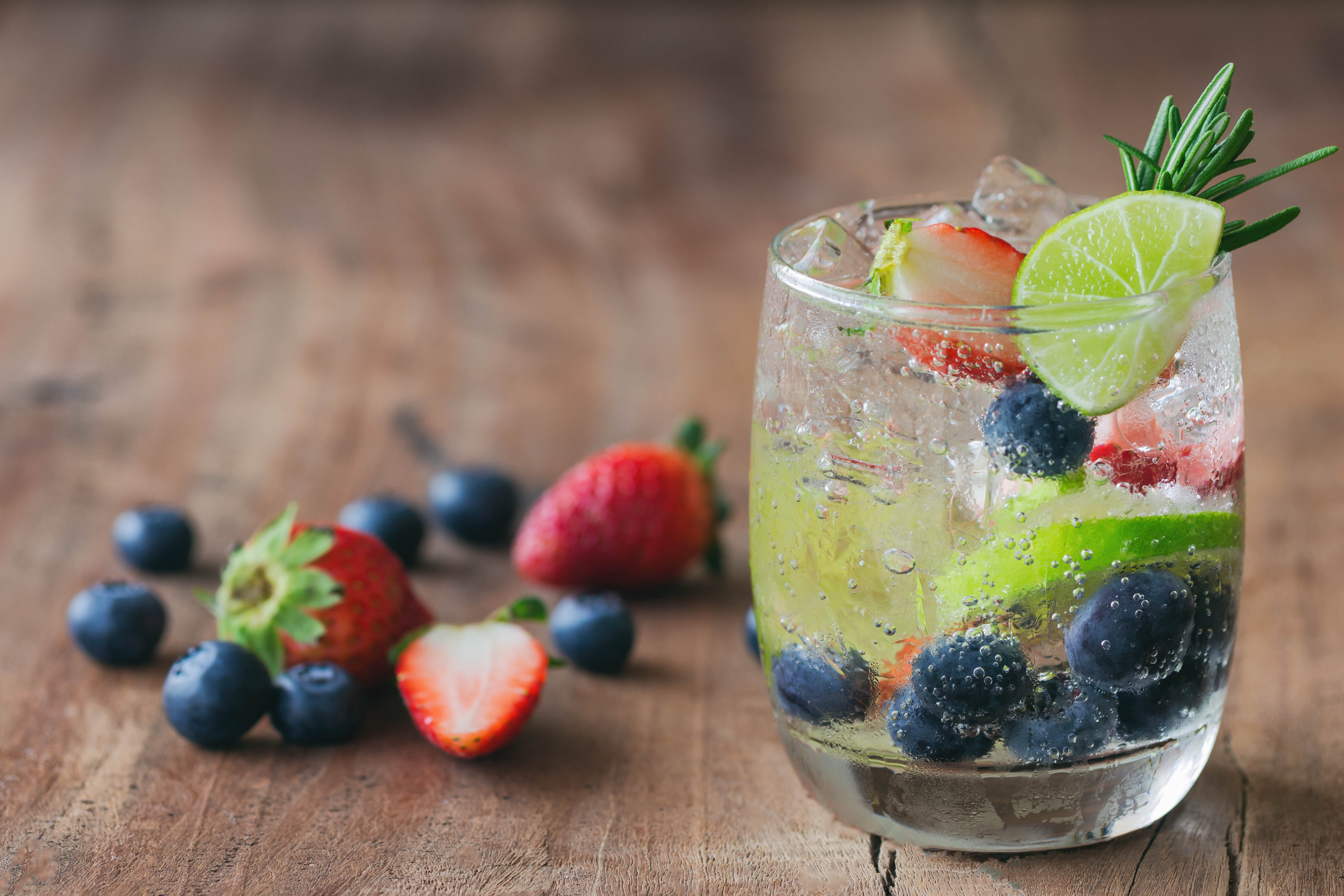 Glass of bubbly water filled with fruits